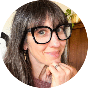 a photo of a Caucasian woman with dark hair and glasses